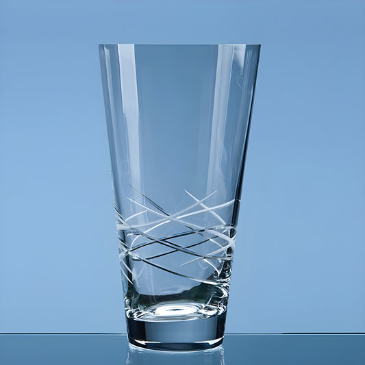 Crystal clear conical vase with geometric design on a blue background.
