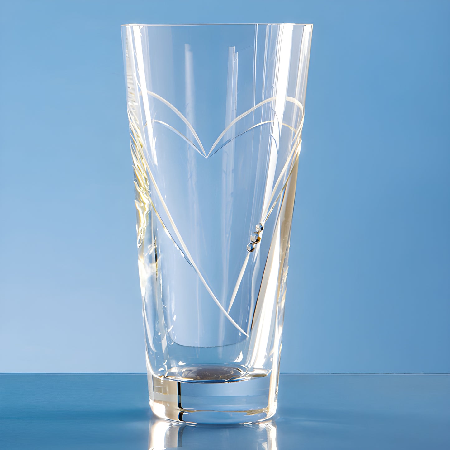 Clear crystal vase with heart-shaped design on blue background.