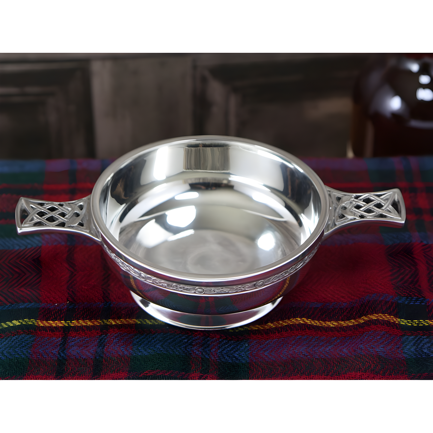 Pewter quaich bowl with Celtic knot handles on tartan cloth