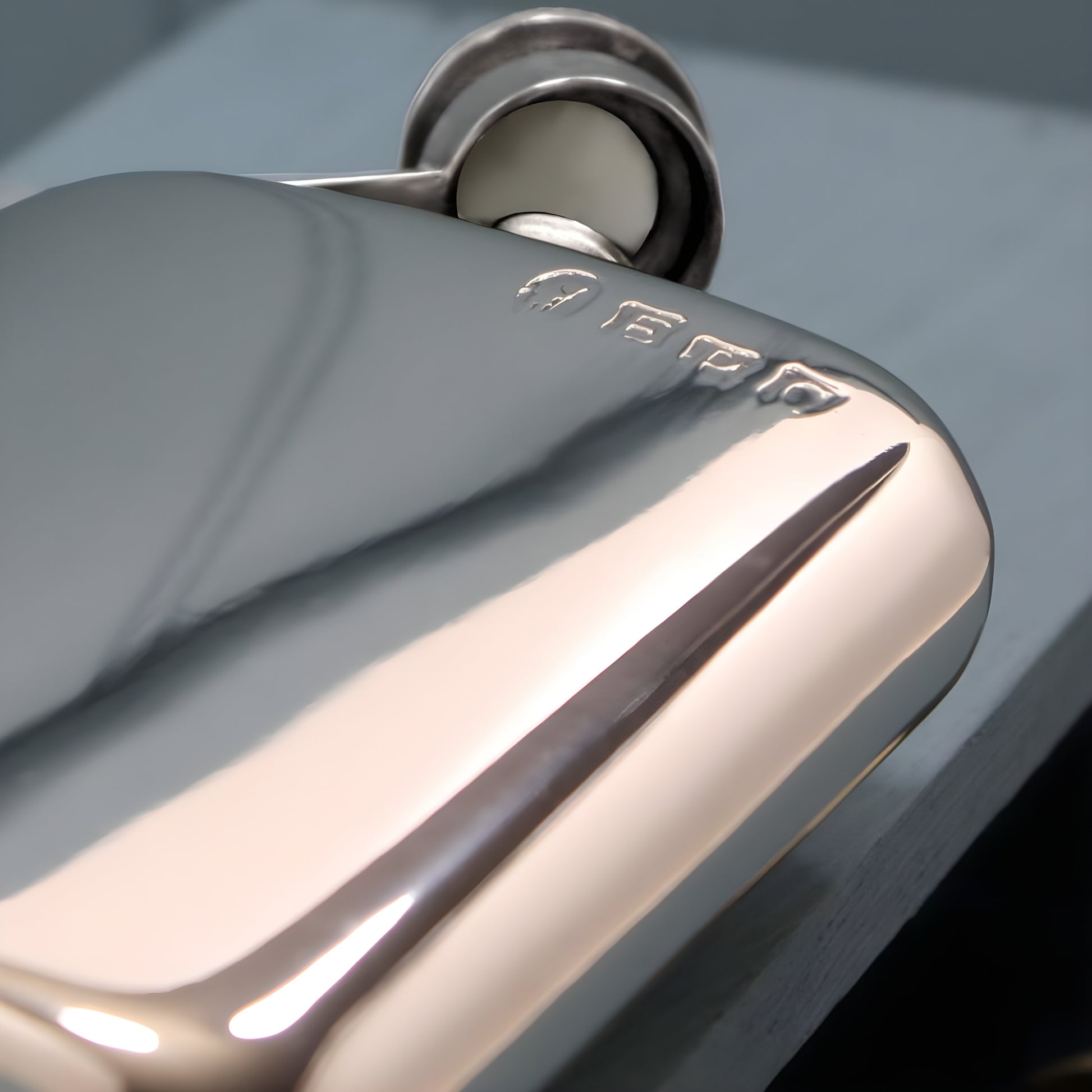 Close-up of a polished 6oz pewter hip flask with engraved detail.