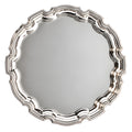 Round scalloped silver serving tray with decorative edges.
