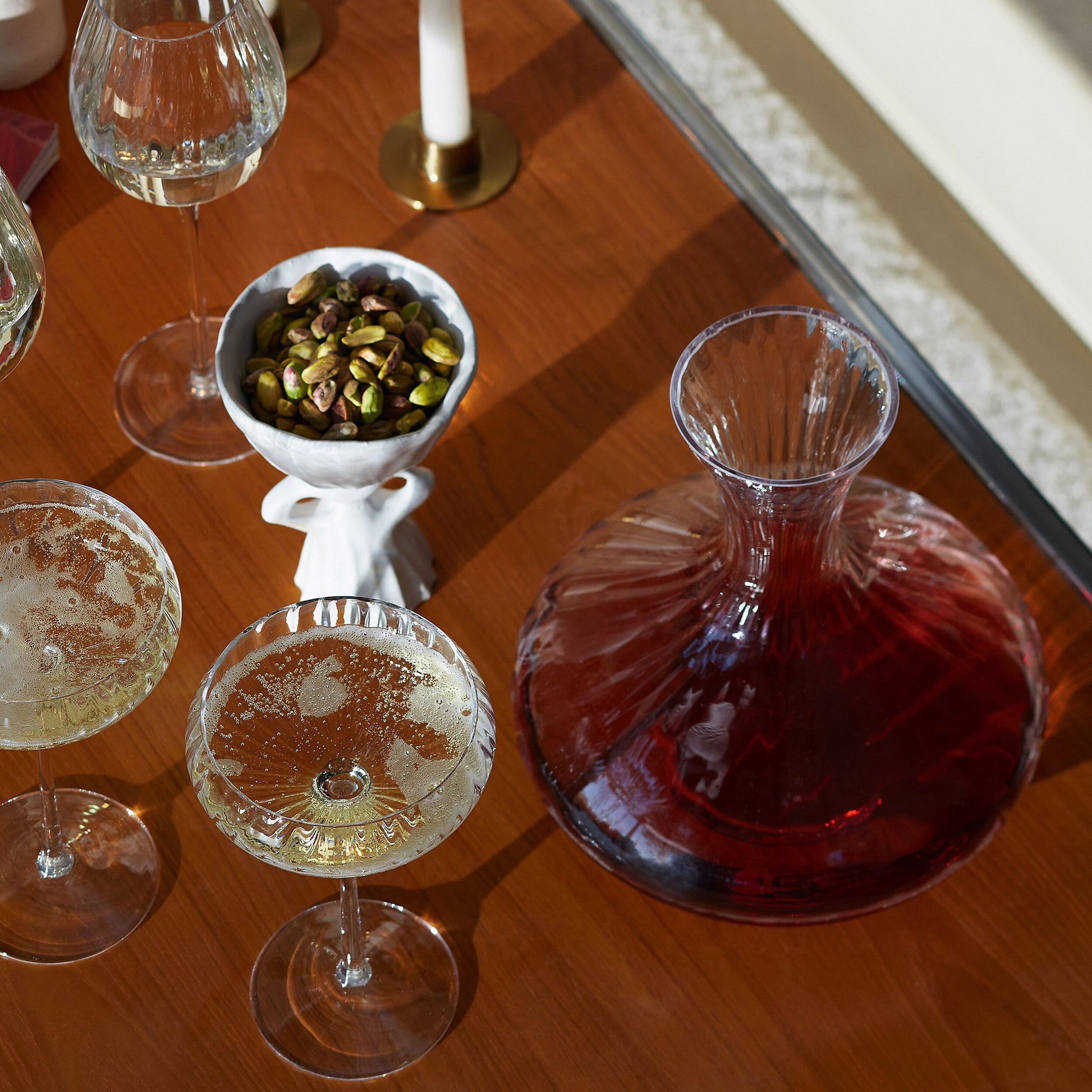 Aurelia carafe with red wine and glasses on a dinner party table with candles.