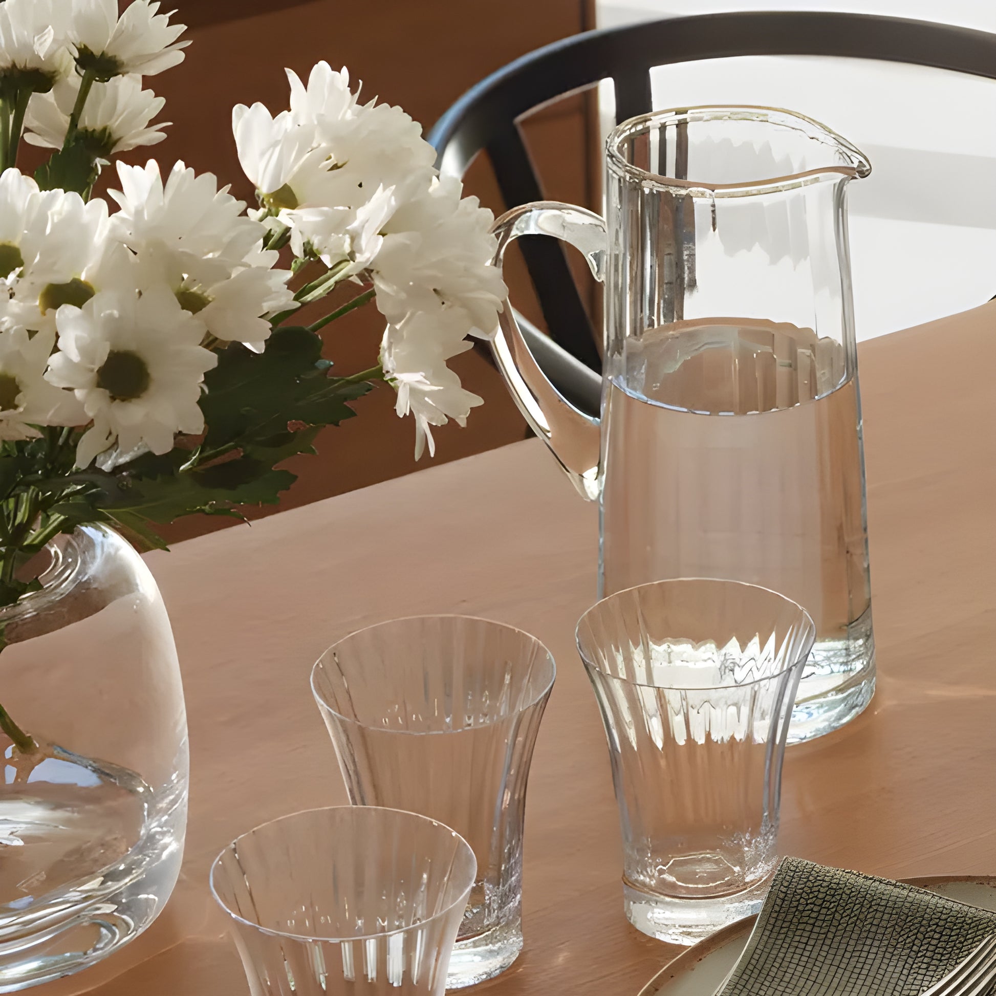 Table with Aurelia glass pitcher, glasses, and flowers.
