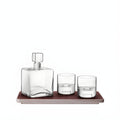 Modern whisky decanter set with glasses on an ash tray.