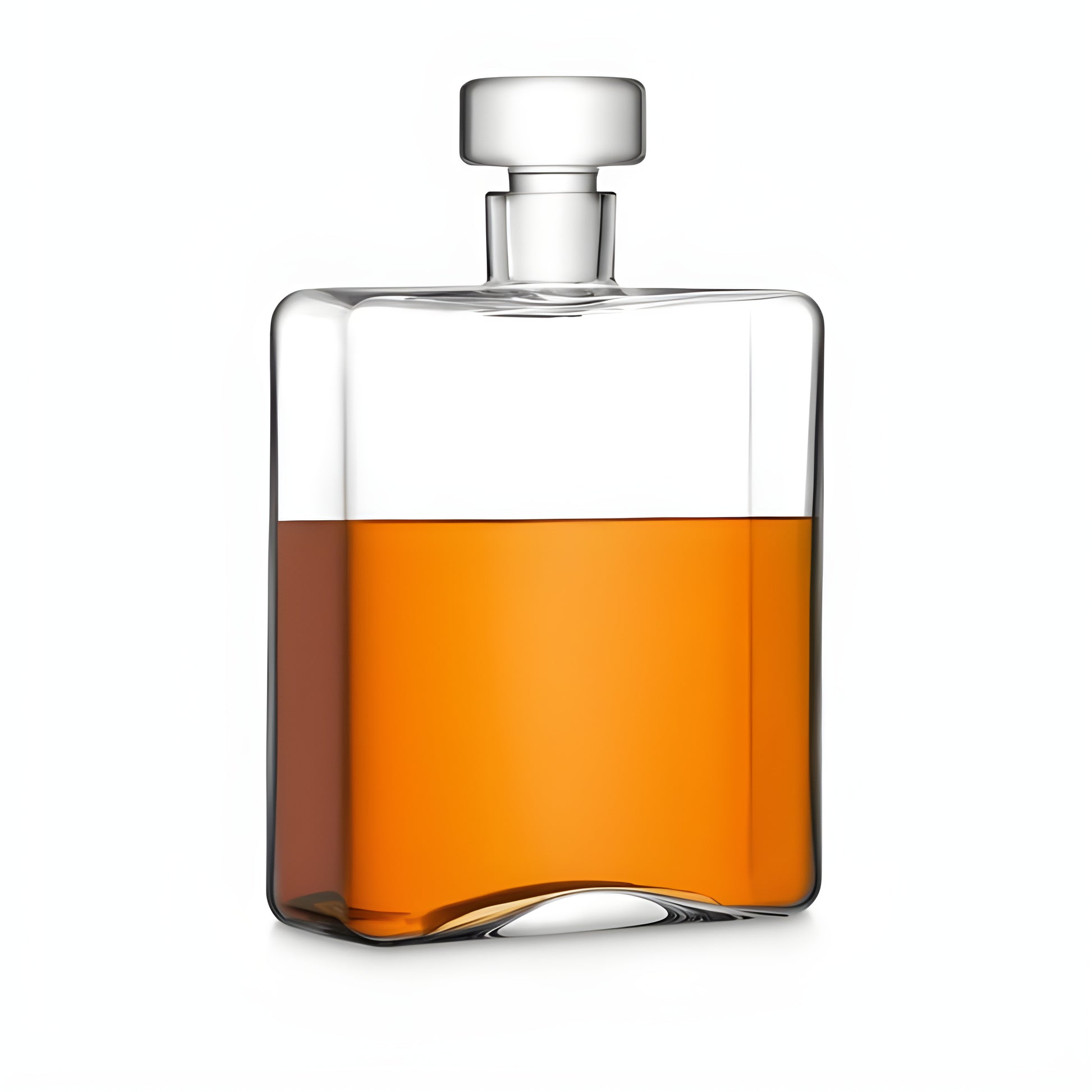 Clear glass oblong decanter filled with whisky against white background.