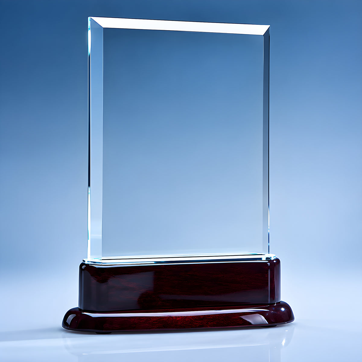 Clear crystal rectangular award on rosewood base against blue background.