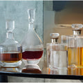 Variety of glass decanters filled with colored liquids on a table.