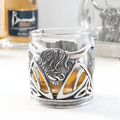Pewter whisky glass with highland cow design and whisky inside.