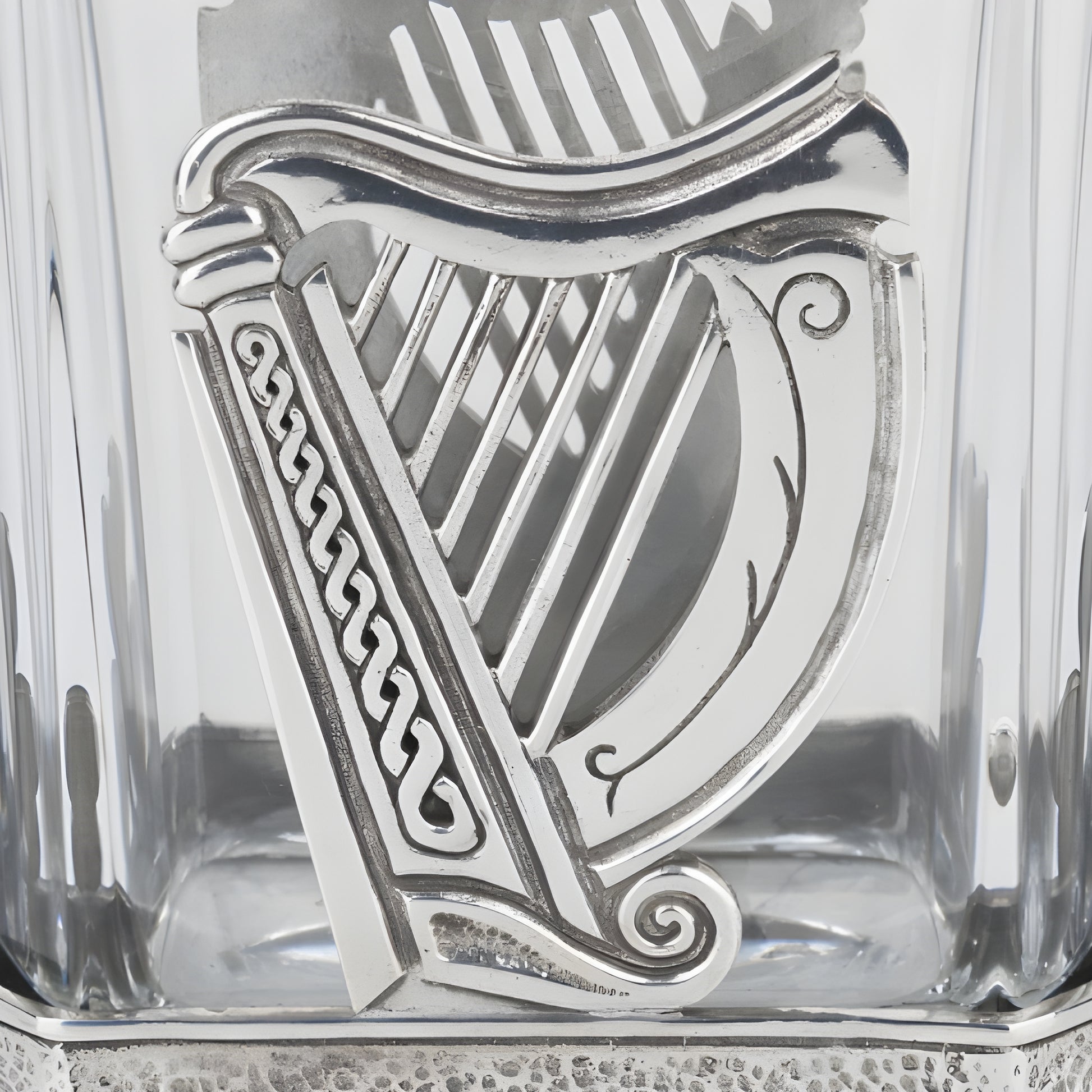 Silver Irish harp ornament on a glass decanter.