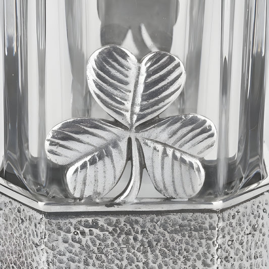 Close-up of a silver shamrock design on a glass decanter base.