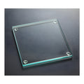 Glass square coaster with jade tint on dark surface