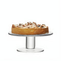 Clear glass cake stand displaying a powdered sugar-topped fruit cake.