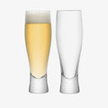 Tall lager glass set with one filled with beer and one empty, Bavarian style.
