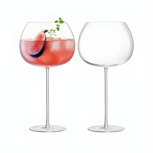 Set of two balloon glasses with pink gin and fig garnish.