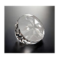 Faceted glass crystal paperweight on a dark surface.