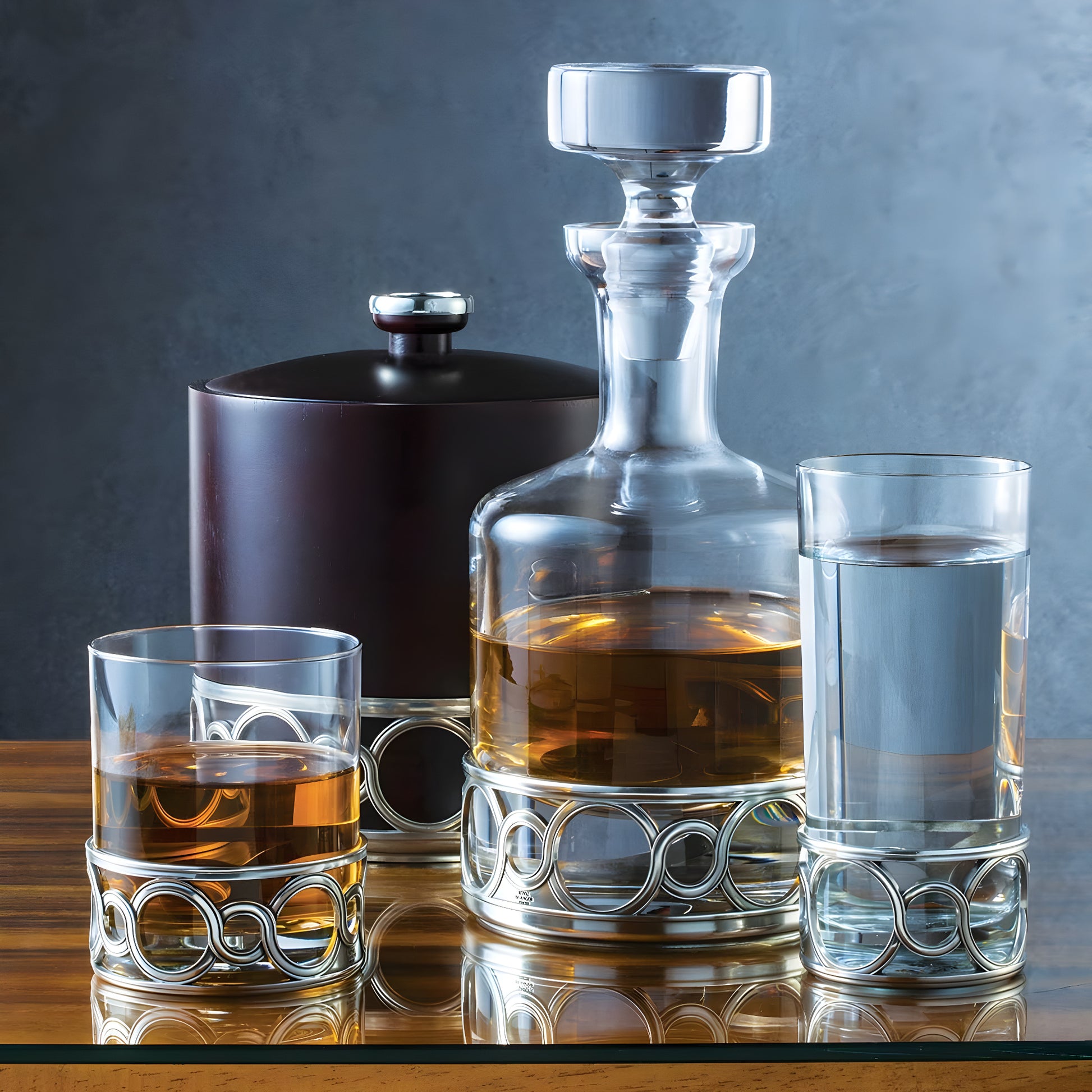 Elegant Royal Selangor medallion whisky tumbler and decanter set on wooden table.