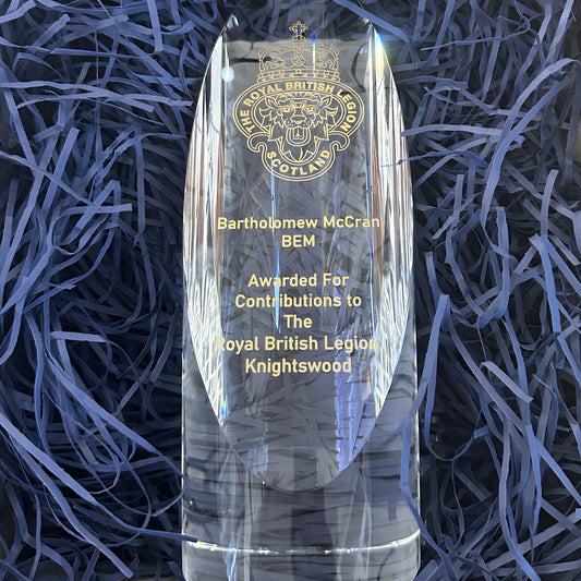 Crystal award for contributions to the Royal British Legion Knightswood displayed on blue paper.