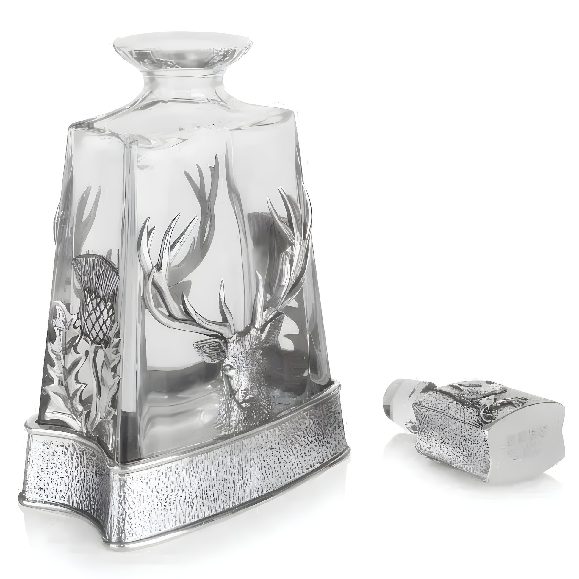 Crystal whisky decanter with stag and thistle design on a reflective surface.