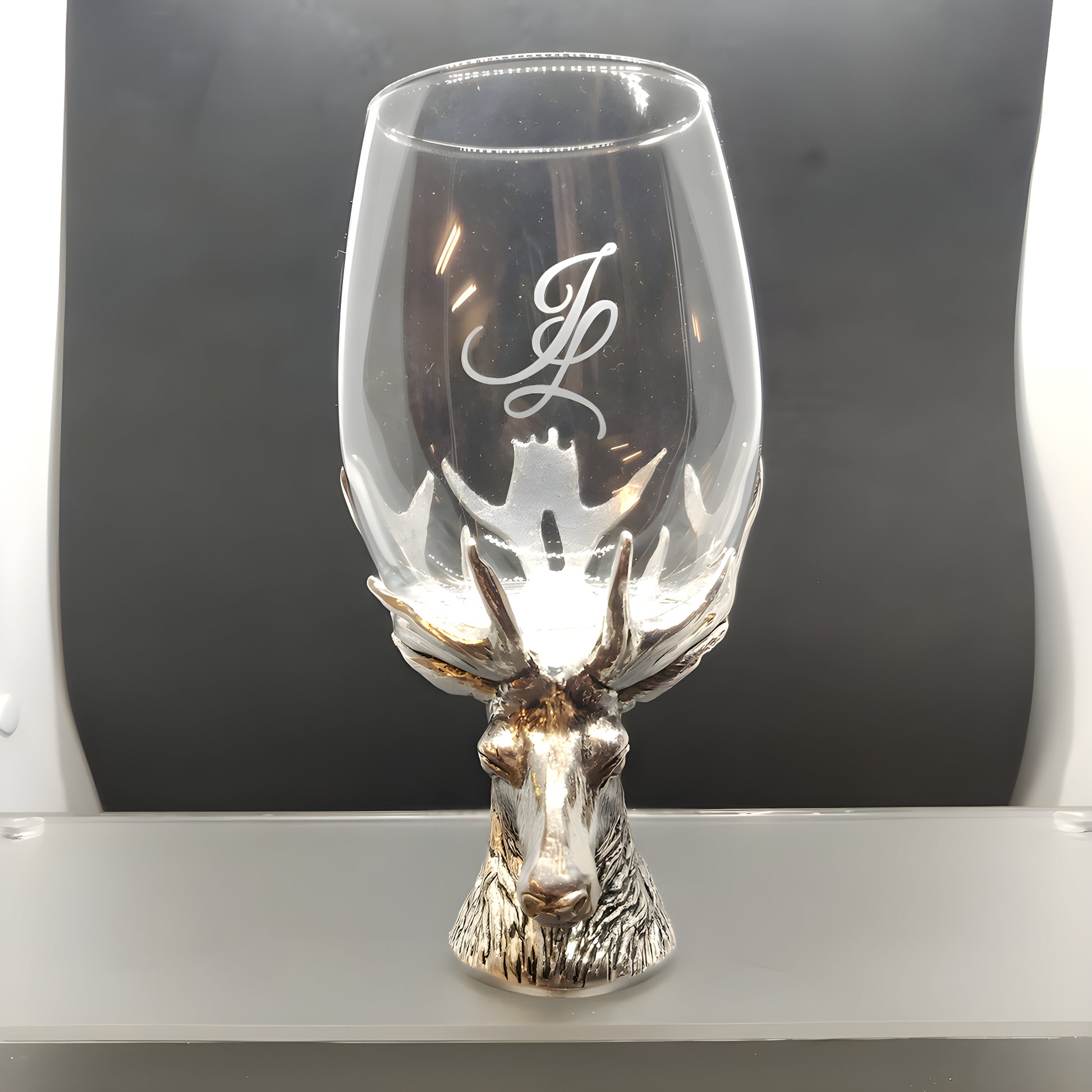 Elegant wine glass with silver stag head stem and monogram engraving on glass.