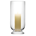 Glass hurricane lantern with lit pillar candle for minimalist decor.