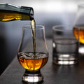 Single malt whisky being poured into a Glencairn tasting glass.