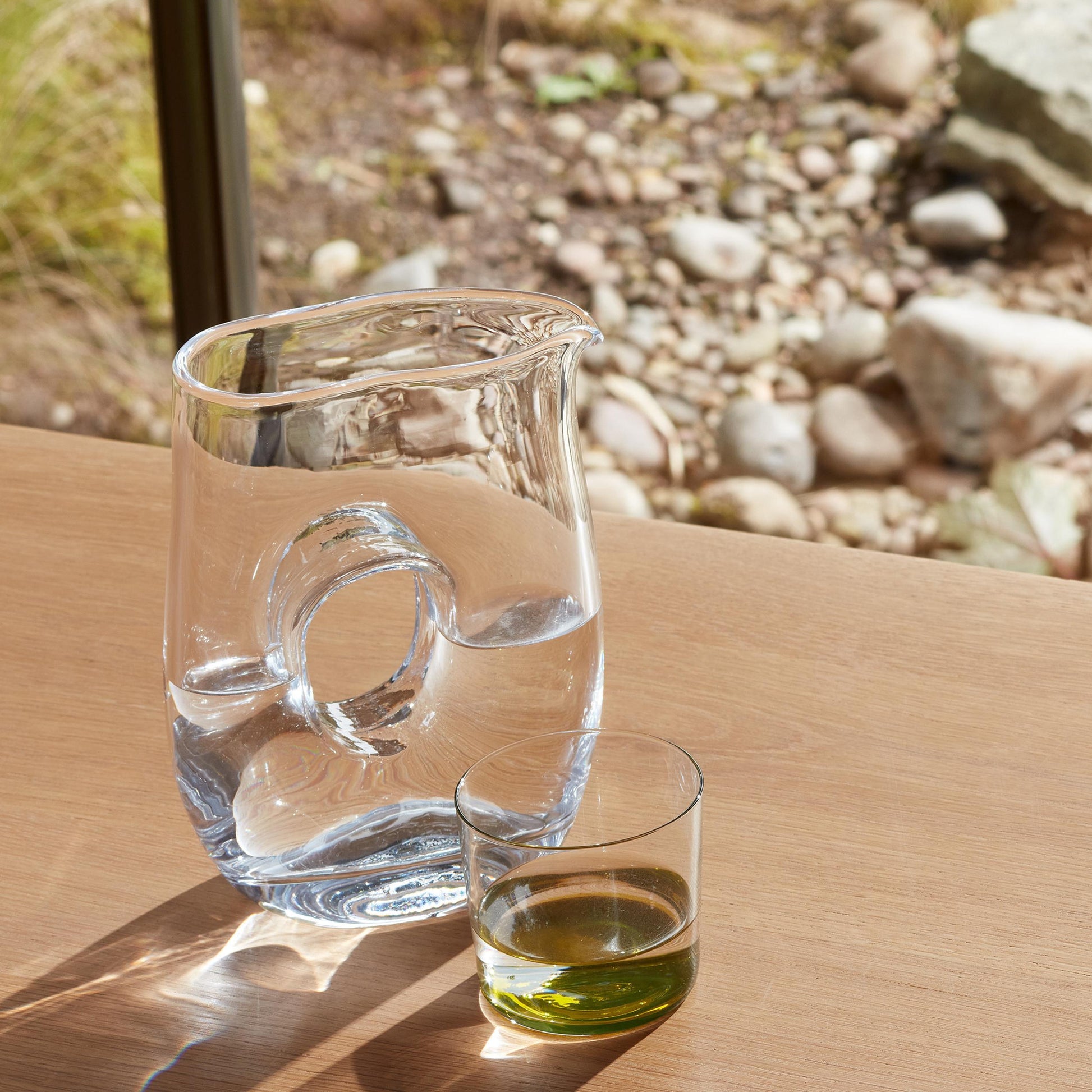 800ml glass jug and glass on table in sunlight scenic backdrop.