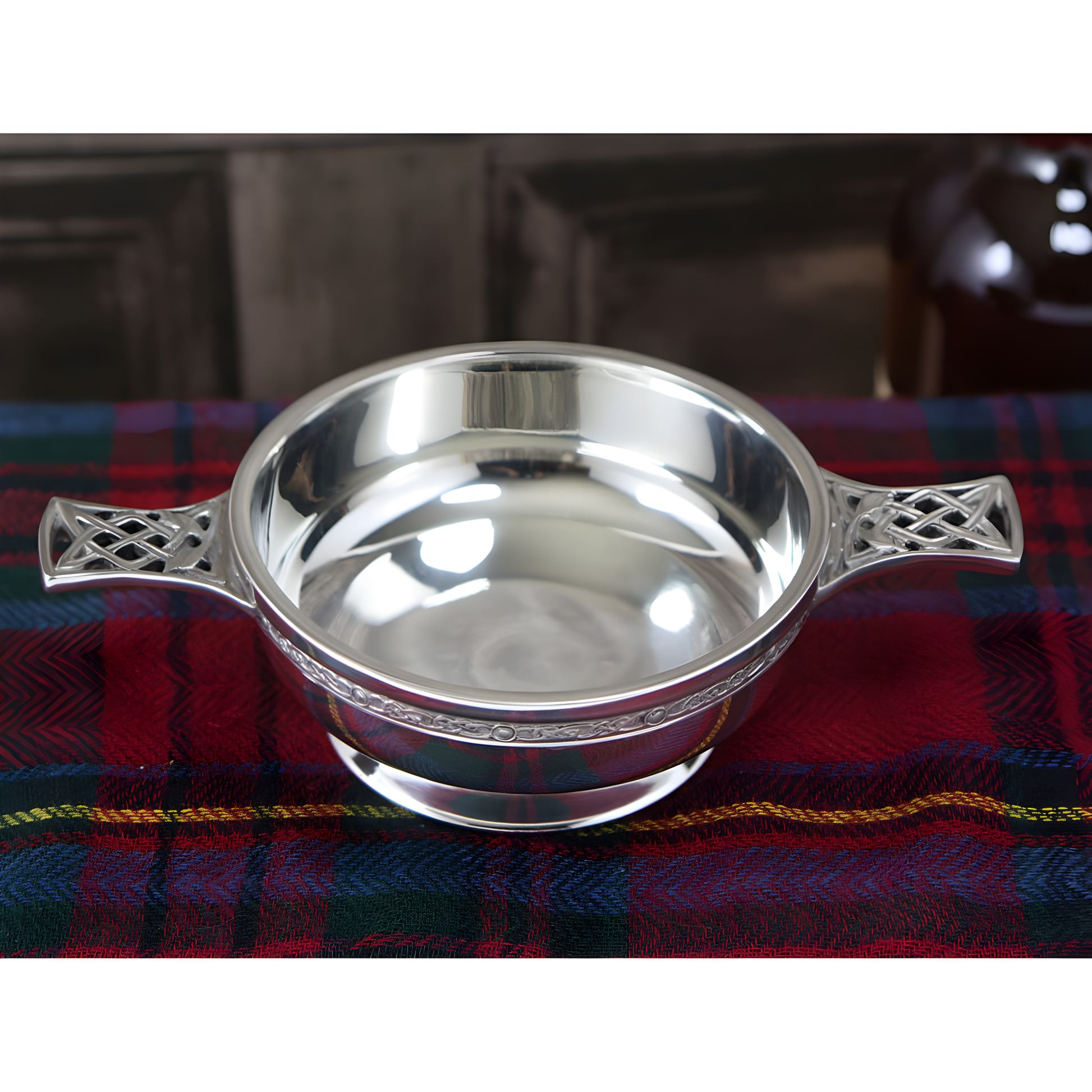 Pewter quaich bowl with Celtic knot handles on tartan cloth