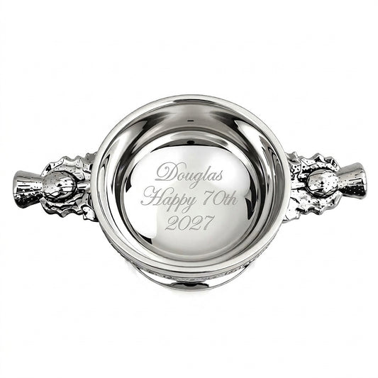 Example engraving (birthday): "Douglas / Happy 70th / 2027" inside the 4" Thistle Handle Pewter Quaich Bowl