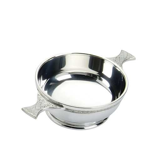 Pewter quaich with Celtic design and two handles on white background.