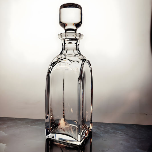 Elegant Atlantis crystal decanter with stopper on reflective surface.