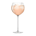 Elegant rose wine with ice cubes in a balloon glass.