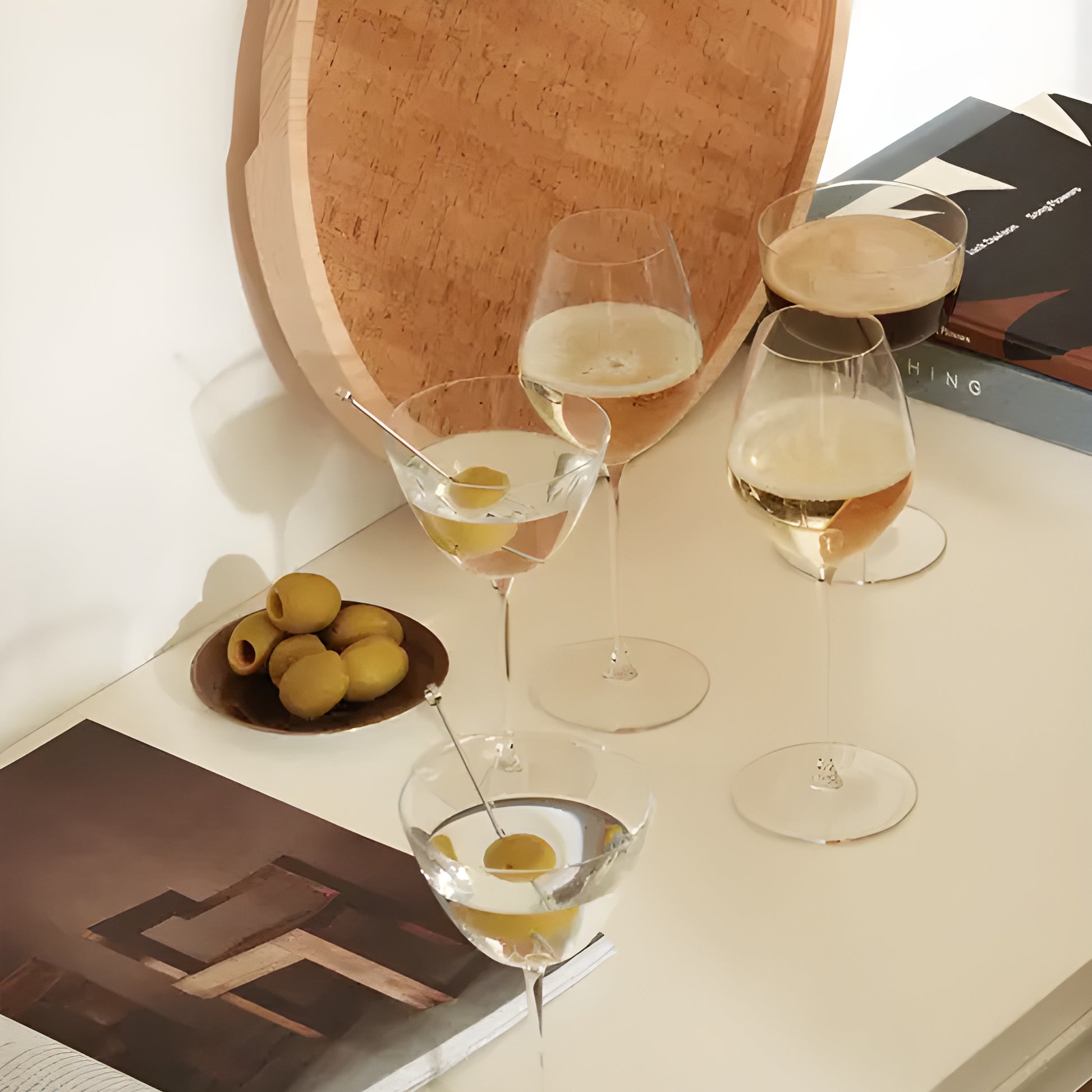 Champagne and olive glasses on a decorated table with books.