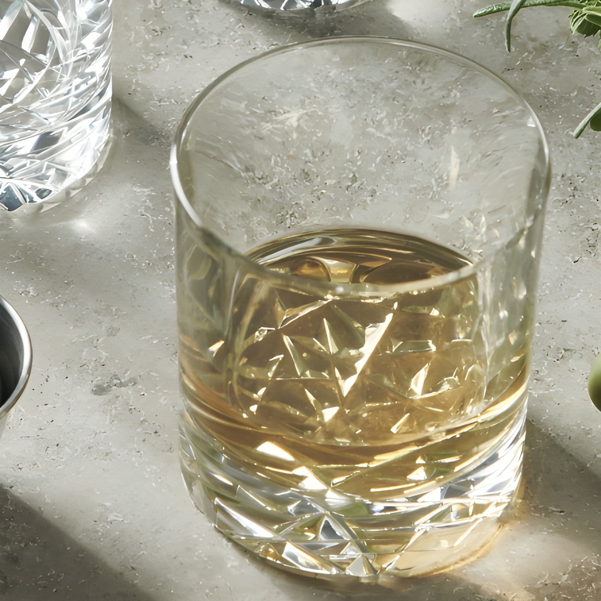 Crystal whiskey glass on a counter filled with light brown liquor.