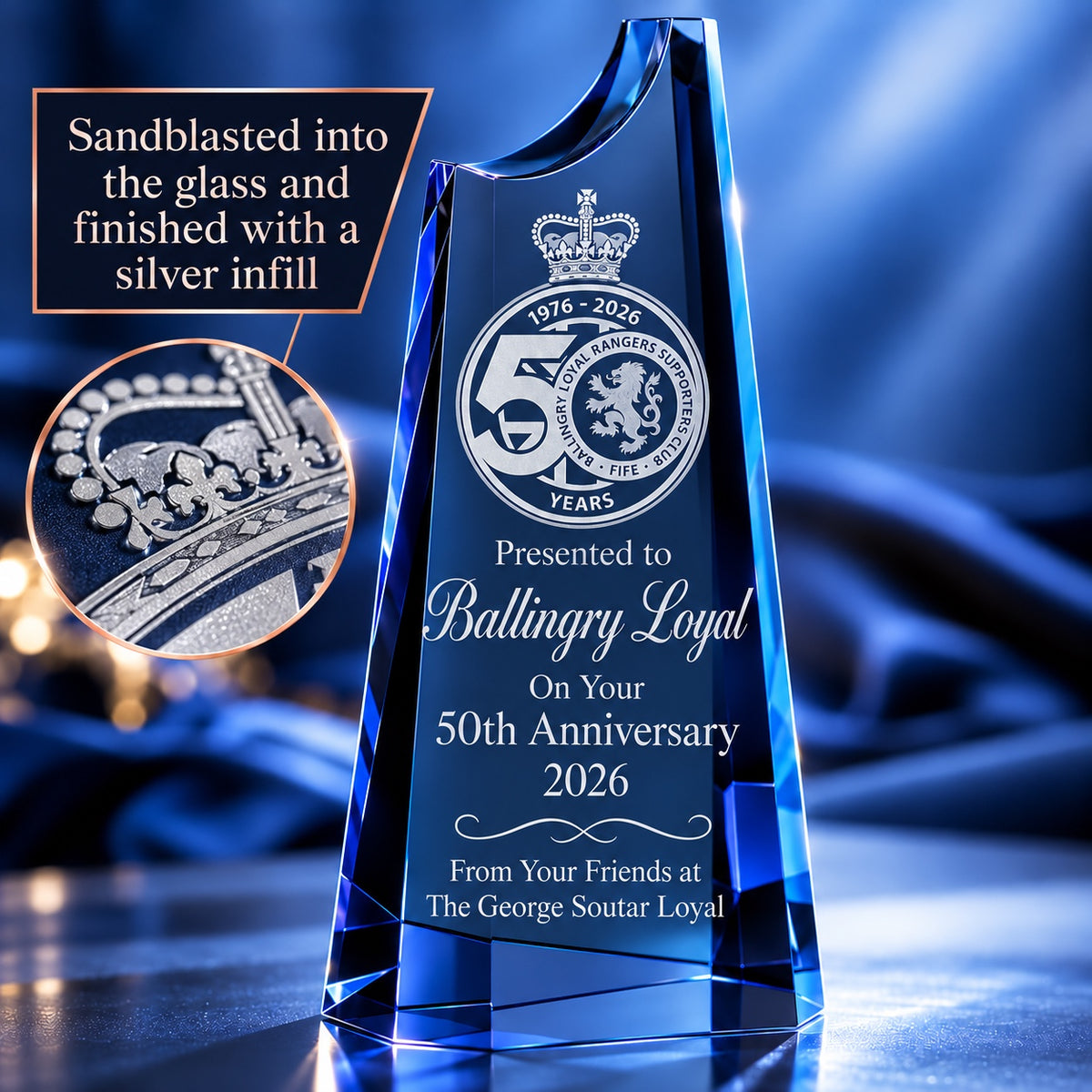 Cobalt blue crystal award sandblasted with a club crest and 50th anniversary message, with a silver infill