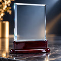 Elegant crystal rectangle trophy on a rosewood base on marble surface.