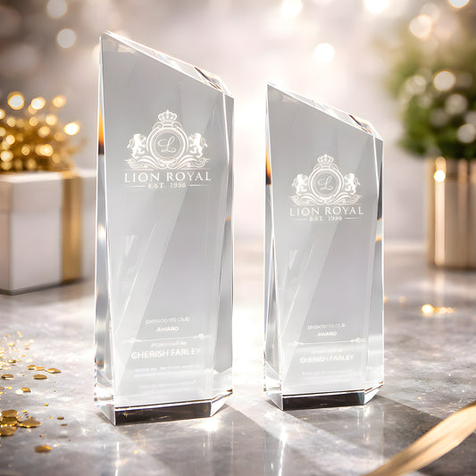Clear glass awards with Lion Royal logo on a decorated table.