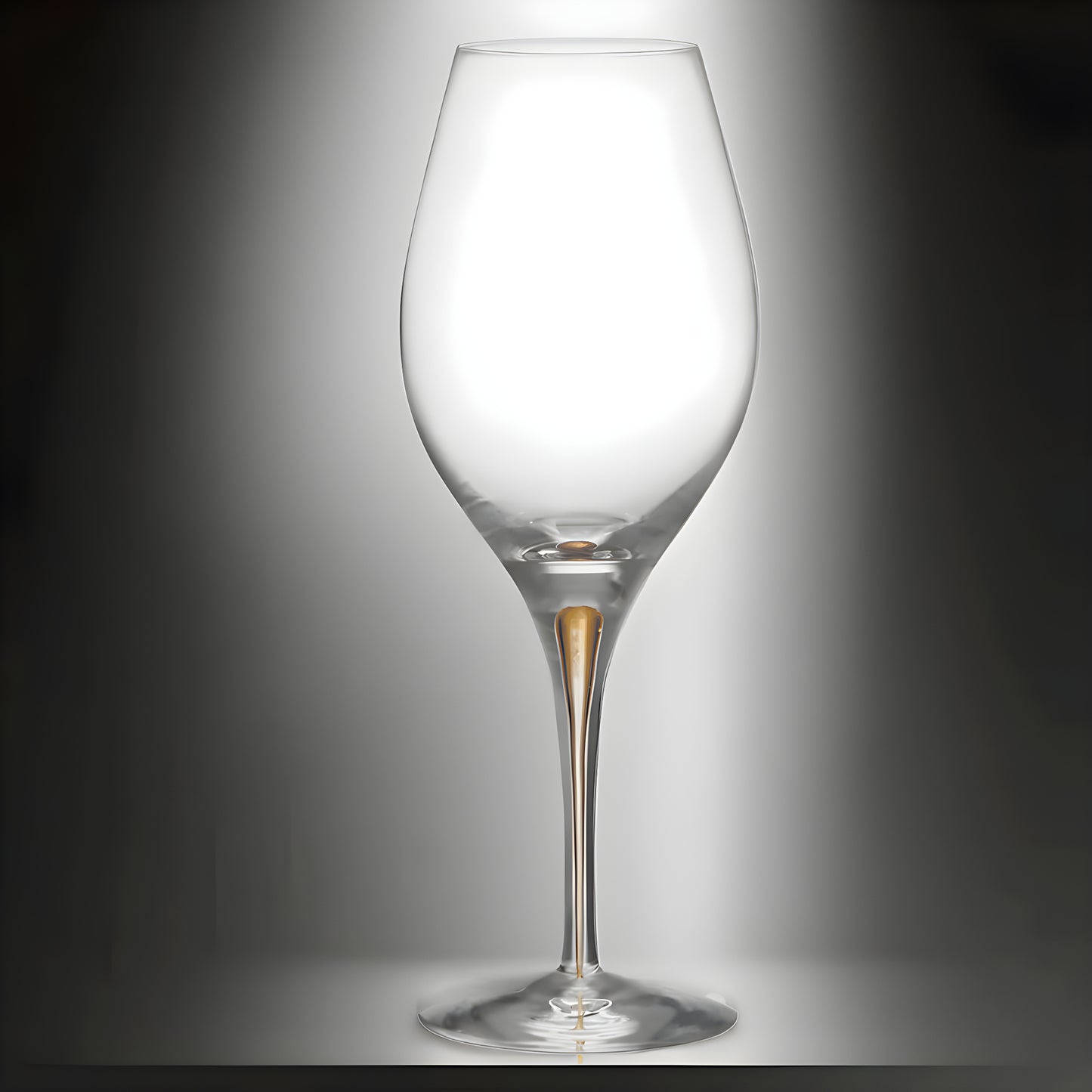 Elegant wine glass with gold stem detail on reflective surface.