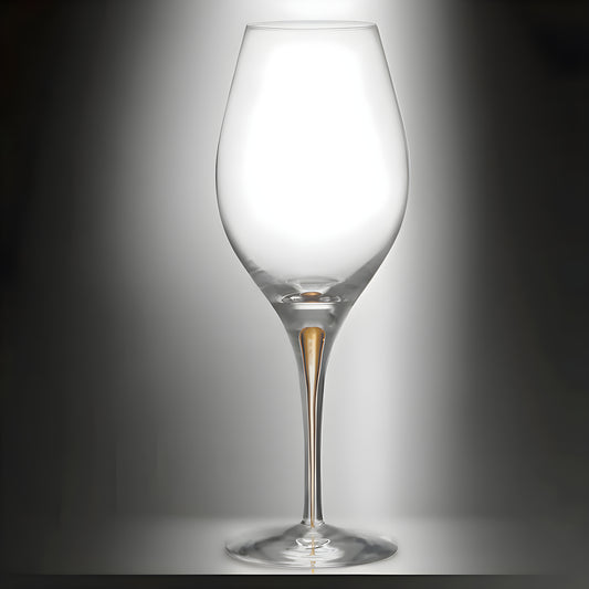 Elegant wine glass with gold stem detail on reflective surface.