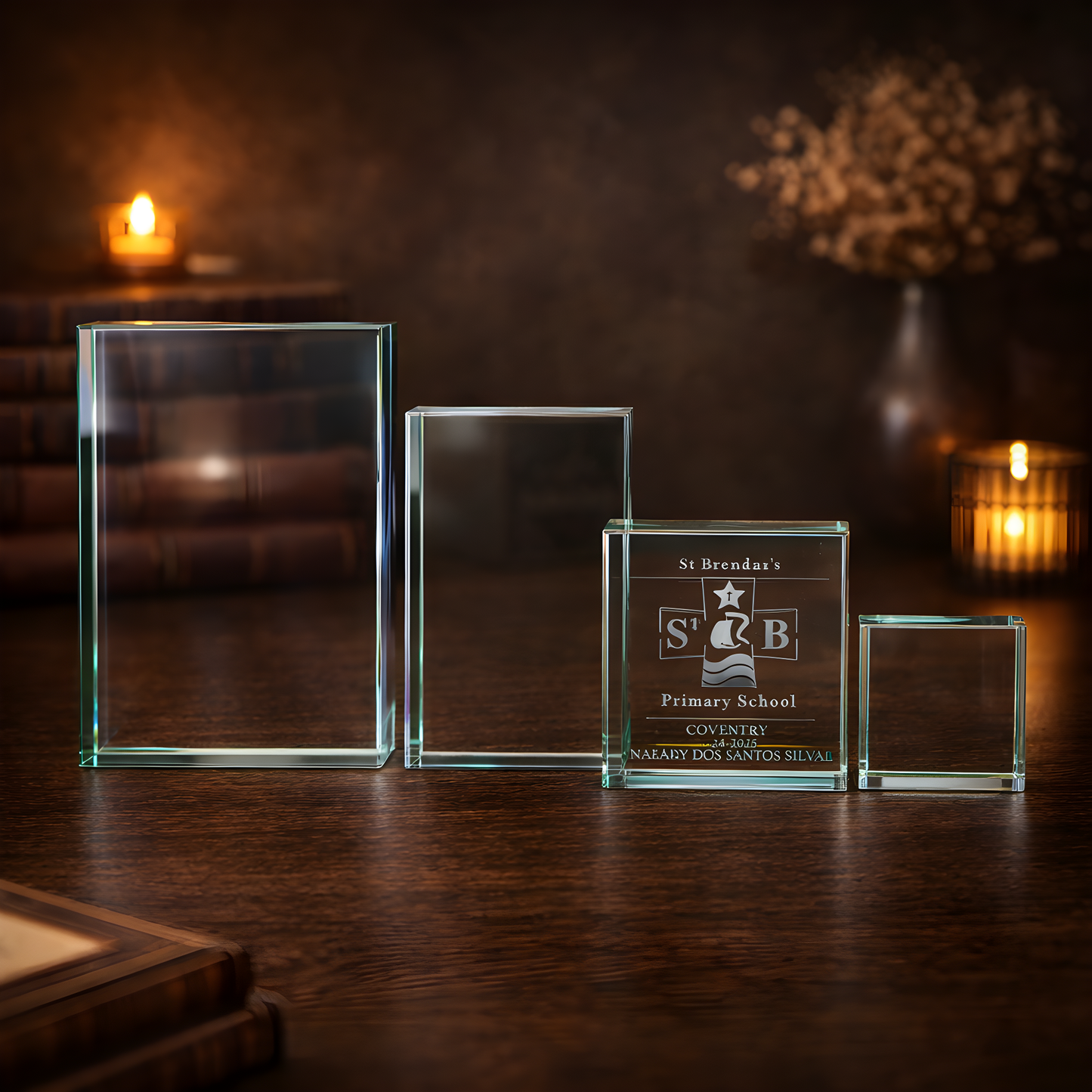 Engraved jade glass award for primary school on a wooden table with candlelight.