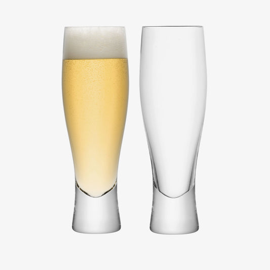 Tall lager glass set with one filled with beer and one empty, Bavarian style.