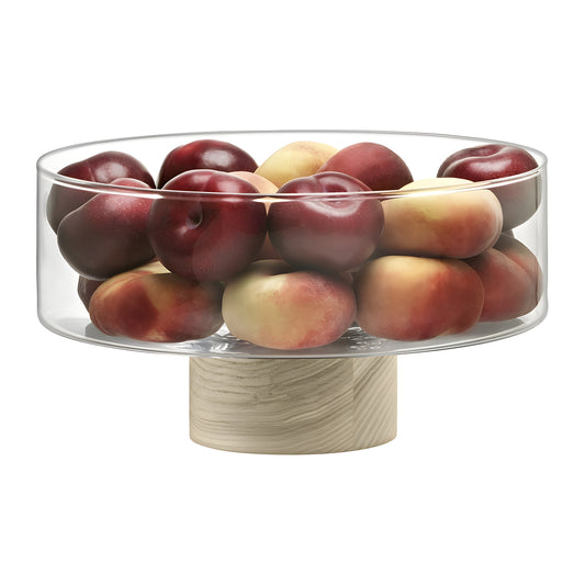 Elegant glass pedestal bowl on ash base filled with fresh red plums.