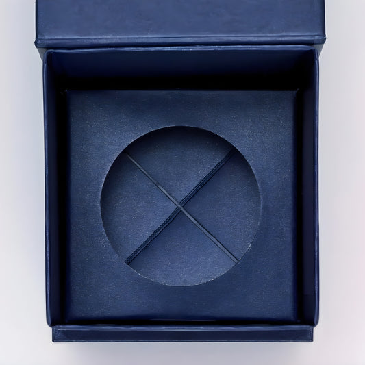 Open navy blue gift box with a textured insert for a small item.