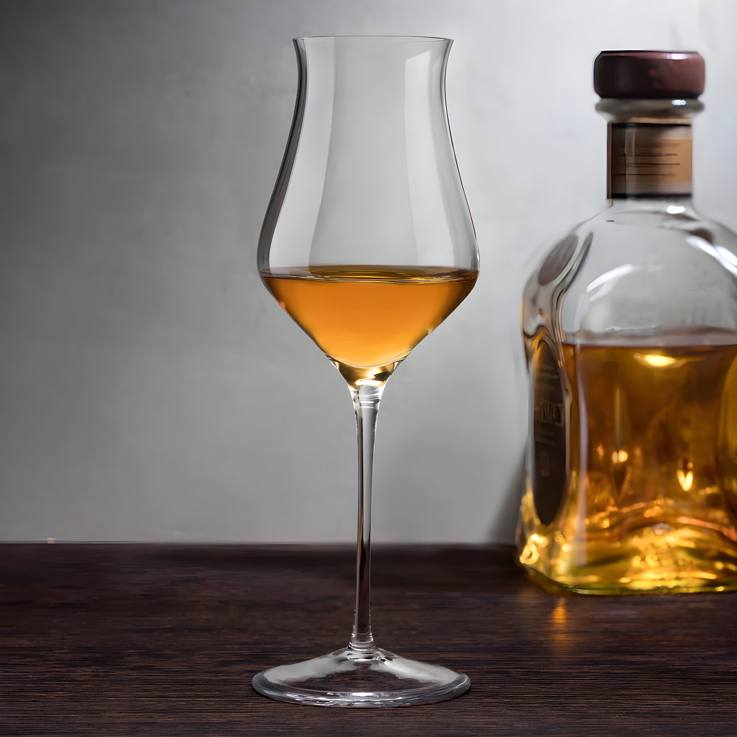 190ml whisky glass filled with brown liquor beside whiskey bottle on wooden surface
