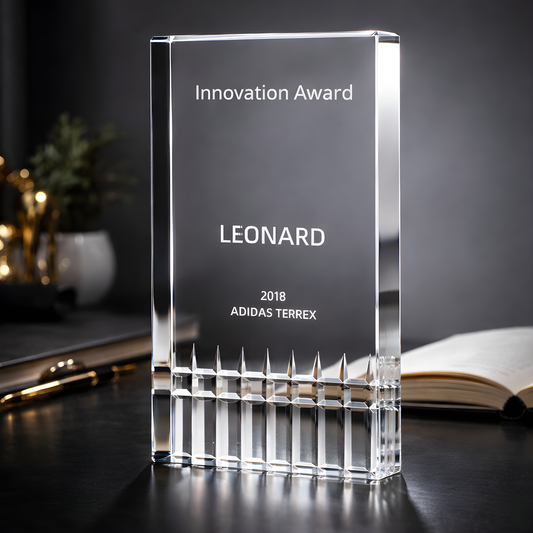 Cut glass innovation award trophy with personalized engraving on table.