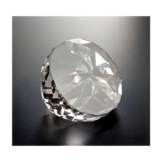 Faceted glass crystal paperweight on a dark surface.