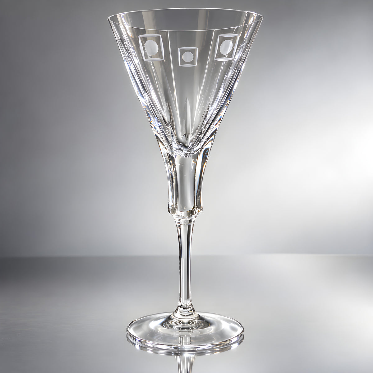 Crystal wine glass with engraved round shapes on a reflective surface.