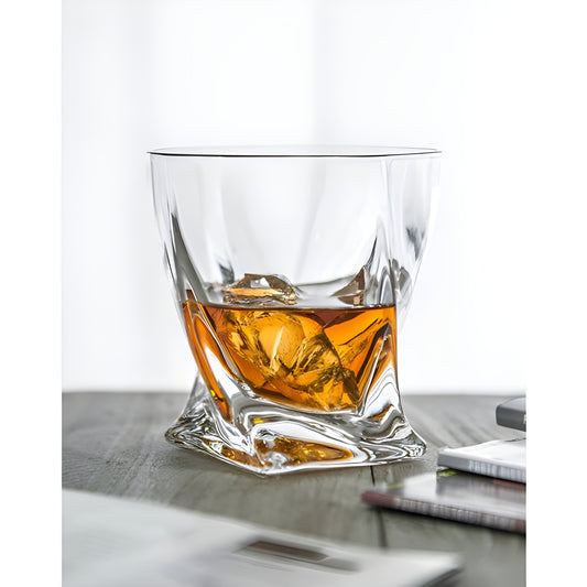Quattro twist whisky glass with ice cubes on a wooden table.