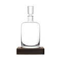 Modern glass decanter with wooden base for serving beverages.