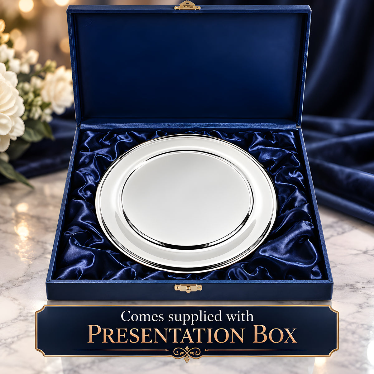 Silver plated Olde English salver in blue velvet presentation box on marble table.
