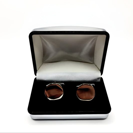 Silver round cufflinks displayed in a chrome box with black interior